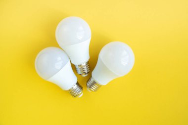 Sarı arka planda üç Led ampul. enerji tasarrufu kavramı