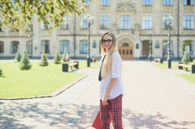 Kampüsteki üniversite öğrencisinin portresi. Okul dosyası olan genç bir öğrenci. öğrenim ve eğitim kavramı