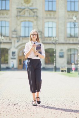 Kampüsteki üniversite öğrencisinin portresi. Genç öğrenci parkta ödev yaparken dizüstü bilgisayar kullanıyor. öğrenim ve eğitim kavramı