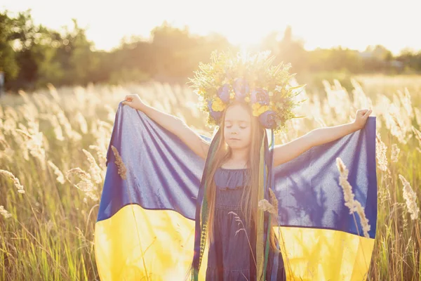Menina carrega fluttering bandeira azul e amarela da Ucrânia no campo . — Fotografia de Stock