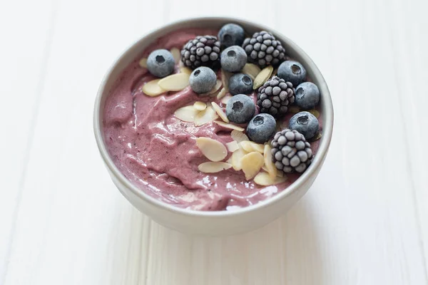 Sund morgenmad bær smoothie skål toppet med banan, granola, Blåbær og chiafrø med kopiplads - Stock-foto