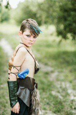 Ukrayna Kozak cosplay. Korkusuz savaşçı gibi davranarak Ukrayna amblemi ile topuz tutan sevimli Kafkas çocuk.