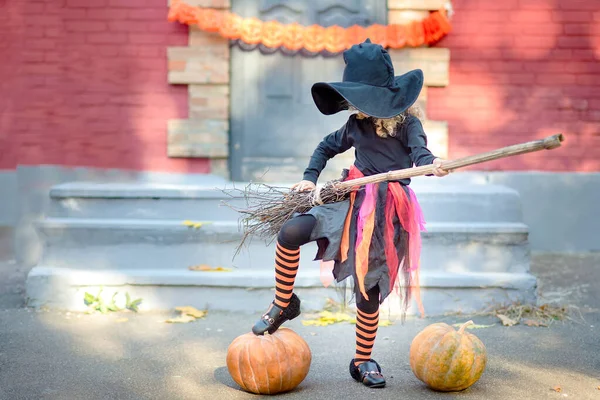 Dziewczynka w stroju czarownicy świętować Halloween na świeżym powietrzu i zabawy. — Zdjęcie stockowe