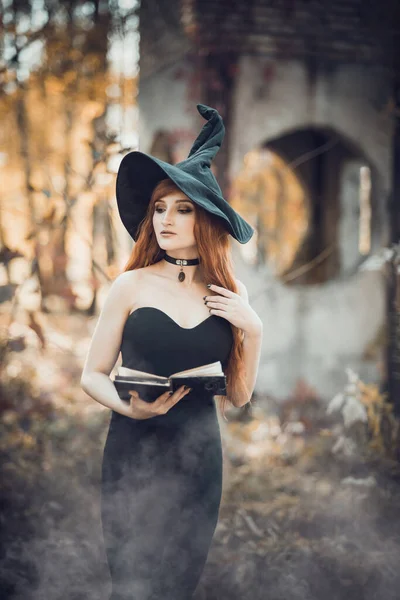 Halloween Beautiful young Witch girl in witches hat