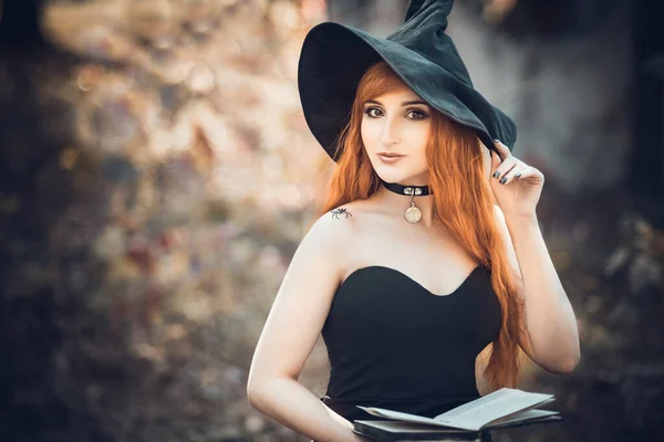 Halloween mooie jonge heks meisje in heksen hoed — Stockfoto