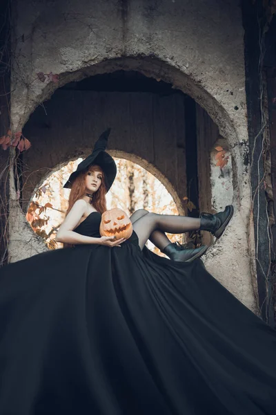 Halloween mooie jonge heks meisje in heksen hoed — Stockfoto
