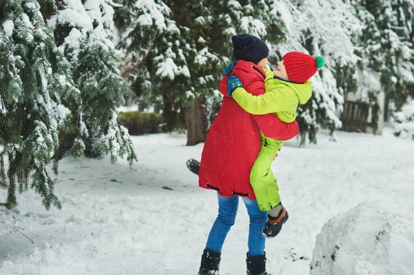 Lycklig Mor Håller Son Händerna Och Leker Snöig Vinterskog — Stockfoto