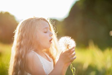 Büyük bir karahindiba ile bir kızın yaz portresi. Çiçeğin yakın fotoğrafını çek. Alerjisi olmayan konsept. Özgürlük