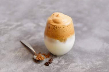 Buzlu Dalgona kahvesi kremalı kremalı espresso köpüklü, şeffaf cam mermer arka planda. Moda içki şehri kapatıldı ve kendini karantinaya aldı. Ev konseptinde kalın..
