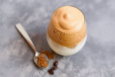 Buzlu Dalgona kahvesi kremalı kremalı espresso köpüklü, şeffaf cam mermer arka planda. Moda içki şehri kapatıldı ve kendini karantinaya aldı. Ev konseptinde kalın..