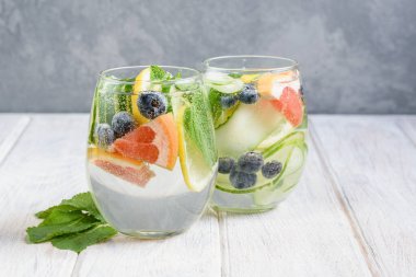 Limon, nane, salatalık, yabanmersini ve greyfurtlu yaz içeceği. Limonata ferahlatıcı ve detoks. Sağlıklı beslenme konsepti. Hafif arkaplan. Yakın plan. Vücut zehirlenmesi.