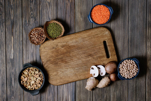 Ноги, чечевица, горох с фасолью вид сверху. Состав различных видов бобовых в чашах на деревянном фоне