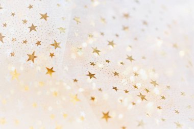 Beyaz şenlik arka planında altın parıltısı ve parıldayan yıldızlar. Kış tatili geçmişi. Noel ve Mutlu Yıllar tebrik kartı. Düğün için. Doğum günü. seçici odak