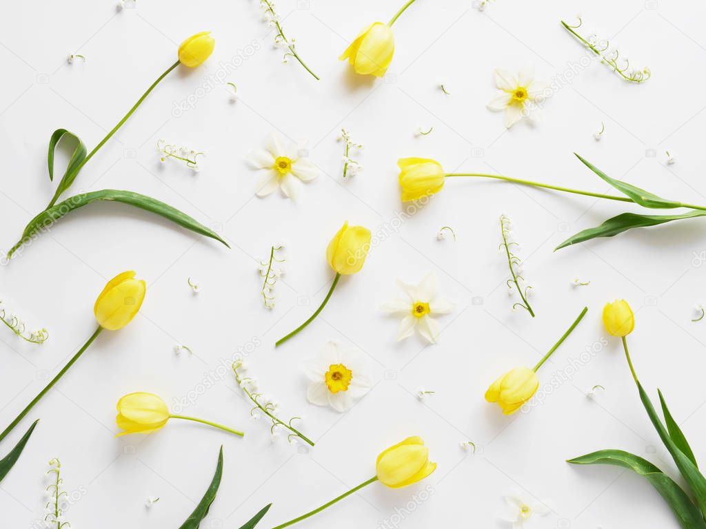 Floral composition with narcissus flowers, lily-of-the-valley and yellow tulips on white background