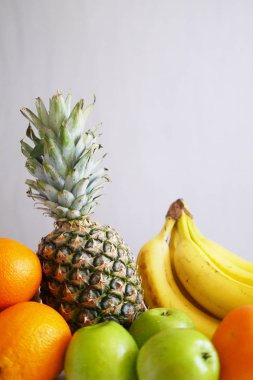 taze meyve yığını, ananas, portakal, elma ve muz gri arka plan üzerinde
