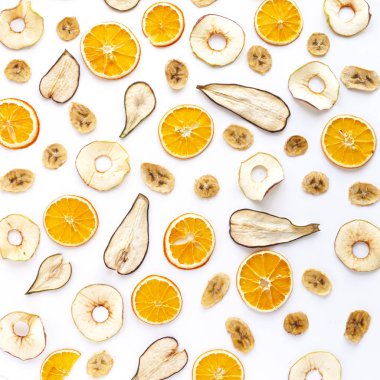 beyaz arka planda kurutulmuş muz, portakal, armut ve elma dilimleri