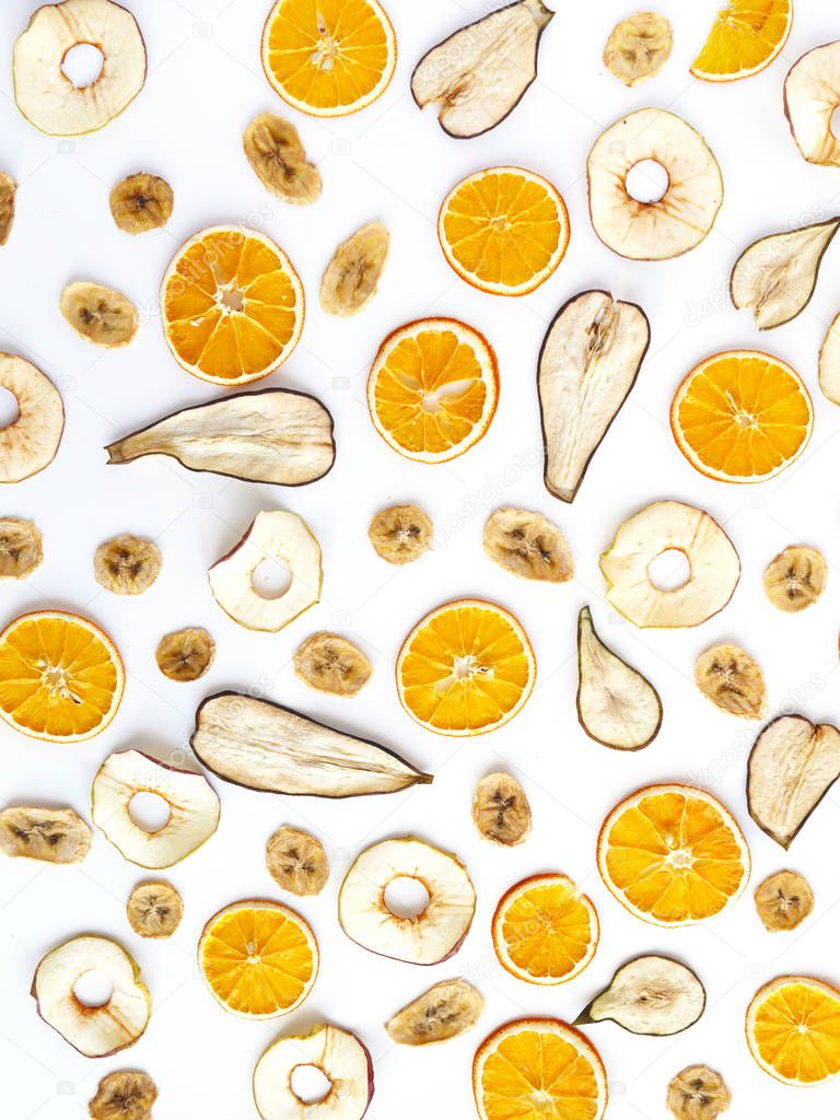 dried banana, orange, pear and apple slices on white background
