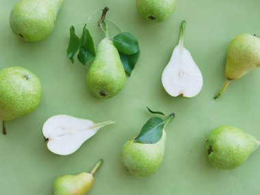 Yeşil arka planda yeşil armutlar, üst manzara, düz yatış. Meyve deseni