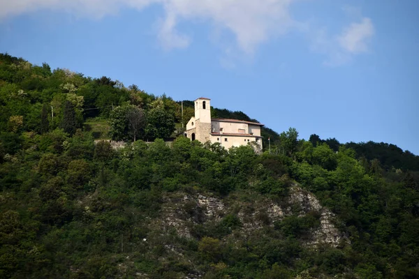 Древняя церковь среди растительности на склонах холма — стоковое фото