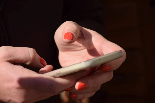 Die schönen Hände einer Frau, während sie mit dem Handy chatten — Stockfoto