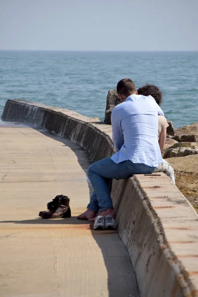 Deniz in önünde genç bir çiftin tatlılık değişimi — Stok fotoğraf