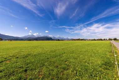 Kırsal manzara yeşil çayır, Alpler ve küçük köy Schwangau yakınındaki Fussen, Ostallgau, Bavyera, Almanya