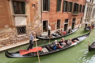 Venedik, İtalya, 13 Eylül 2015: Gondolda gondolcu ile tipik Venedik satır tekne oturan turist grup. Gezi turuna ünlü şehir dar kanallar boyunca.