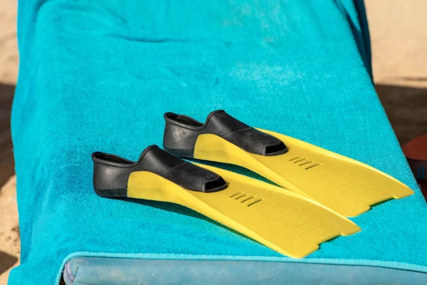 Black and Yellow Diving Fins on a Blue Towel — Stock Photo, Image