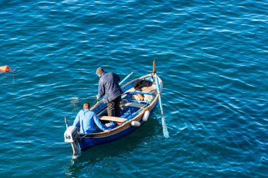 Riomaggiore, İtalya - 2 Ocak 2015: İki Balıkçılar küçük bir ahşap teknede balık küçük bağlantı noktası, Riomaggiore, Cinque Terre, Liguria, İtalya için dışarı geliyor