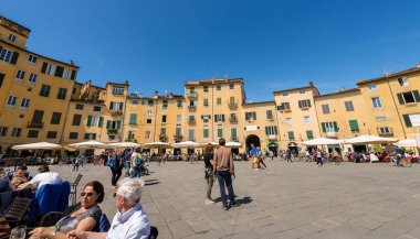 Lucca, İtalya - 16 Nisan 2017: Turistler ve yerliler için eski şehir Meydanı (Piazza dell'Anfiteatro - amfi tiyatro kare) ziyaret Lucca küçük eski şehir, Toscana (Toskonya), İtalya, Avrupa