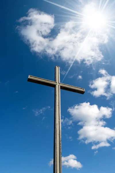 木基督徒十字架在蓝天与云彩和太阳光芒 宗教标志 — 图库照片
