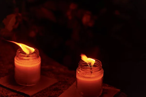 Дві воскові свічки в скляних банках з запаленим полум'ям — стокове фото