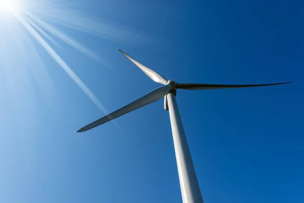 太陽光線とコピー スペース 再生可能エネルギーの概念の澄んだ青い空に風タービンのクローズ アップ — ストック写真