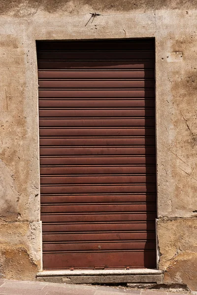 Antiguo obturador de rodillo cerrado oxidado de una tienda — Foto de Stock