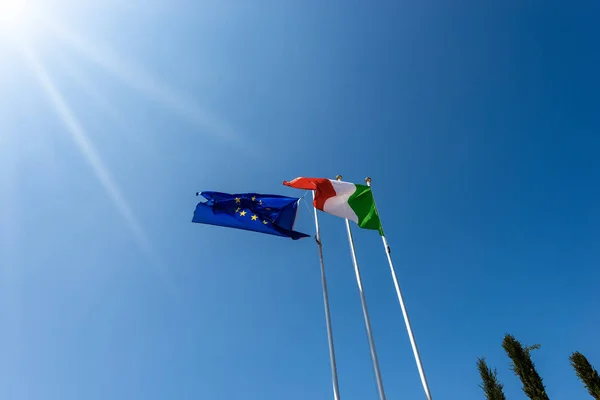 Italienska och Europeiska unionen flaggor viftar i himlen — Stockfoto