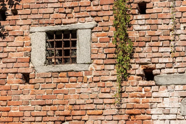 Středověká cihlová zeď-okno s tepané železnou tyčí — Stock fotografie