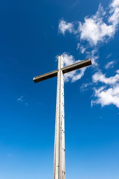 Houten christelijke kruis op blauwe hemel met wolken — Stockfoto