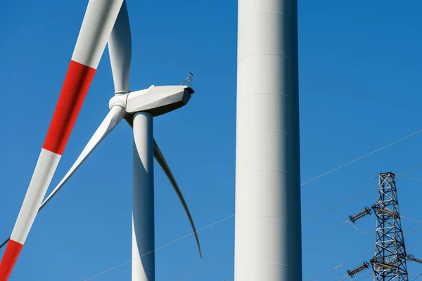 Turbina wiatrowa i wieże wysokiego napięcia - energia odnawialna — Zdjęcie stockowe