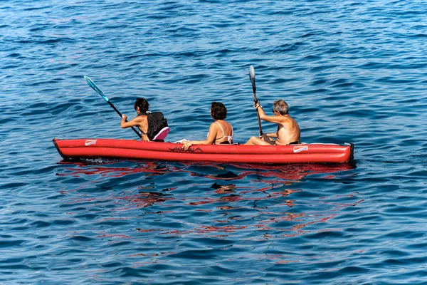 Tres adultos mayores haciendo kayak en el mar azul - Liguria Italia —  Fotos de Stock