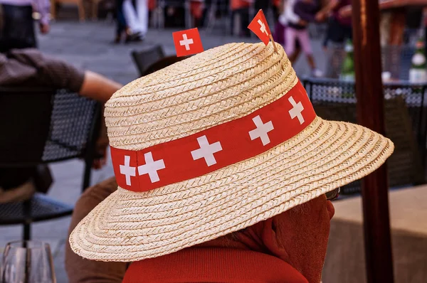 Mann mit Strohhut mit Schweizer Fahnen — Stockfoto