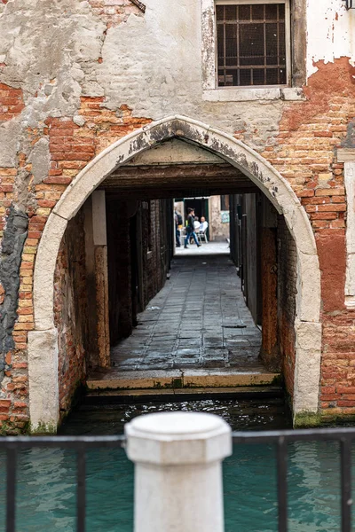 Narrow alley with arch and canal in Venice Italy — Stock Photo, Image