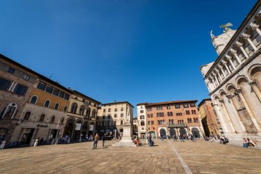 LUCCA, ITALY - 16 Nisan 2017: Piazza San Michele (Kasaba Meydanı) Foro Kilisesi (San Michele) ve ortaçağ sarayları. Lucca, Toskana, İtalya, Avrupa