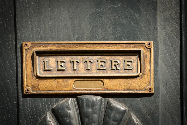 意大利利古里亚的木制前门 一个印有意大利语文本的黄铜信箱的闭锁 — 图库照片