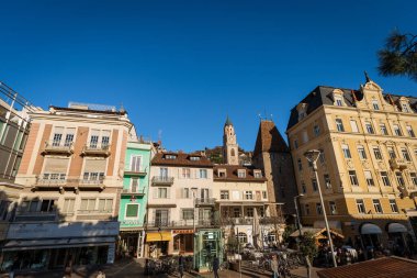 Merano, İtalya - 7 Aralık 2015: Merano, Piazza della Rena (Rena Meydanı) şehir merkezinde, San Nicolo Katedrali 'nin çan kulesi ve Porta Bolzano (Bolzano kapısı) ile birlikte. Trentino Alto Adige, İtalya