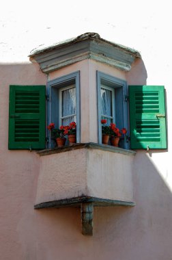 Küçük Tiran, İtalyan Alpleri, Valtellina, Sondrio vilayeti, Lombardy, İtalya ve Avrupa 'da küçük ahşap pencereleri ve kırmızı sardunyaları olan küçük eski balkon.