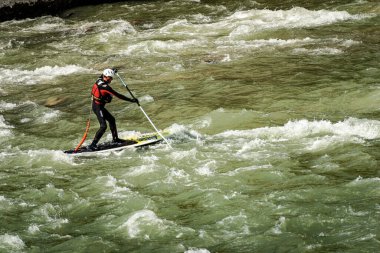 VERONA, ITALY - SEPT 19, 2020: Stand up Paddleboard (SUP) 'unda bir adam, Verona şehir merkezindeki Adige nehrinin akıntılarında akıntıya karşı kürek çekiyor. Veneto, İtalya, Avrupa