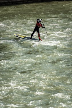VERONA, ITALY - SEPT 19, 2020: Stand up Paddleboard 'unda (SUP) bir adam, Verona şehir merkezindeki Adige nehrinin akıntılarında kürek çekiyor. Veneto, İtalya, Avrupa