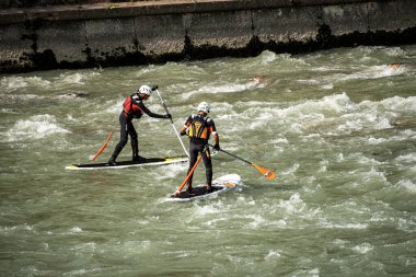 VERONA, ITALY - SEPT 19, 2020: Stand up Paddleboard 'larında (SUP) iki adam, Verona şehir merkezindeki Adige nehrinin akıntılarında kürek çekiyorlar. Veneto, İtalya, Avrupa