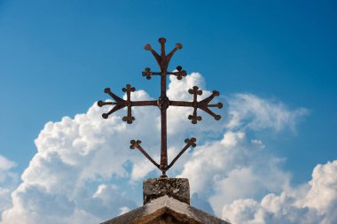 Ortaçağ Hıristiyan haçı, bulutlu mavi gökyüzünde dövülmüş demir. Verona, UNESCO dünya mirası bölgesi, Veneto, İtalya, Avrupa.