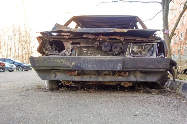 Verlaten verbrand personenauto in de buurt van het appartementencomplex. Rusland. — Stockfoto